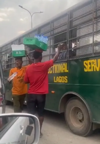 Traffic hawker captured giving out money to prisoners in a correctional service vehicle in Ajah, Lagos (Video)